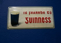 Guinness sign written in Gaelic on Pub wall. **Editorial Use Only**