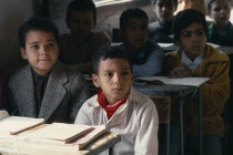 Primary schoolchildren sitting at desks in classroom of village school.