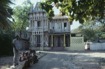 Typical domestic architecture.  Colonial style home with children sitting outside.