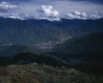 View from above across city  valley and surrounding mountains.