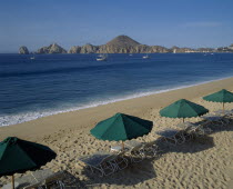 Menano beach area View over beach to surrounding coastline Sun longers & shades in foreground