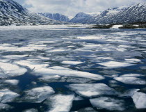 Geiranger Fjord - Spring melting ice snowy mountains behind