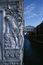 The Dogs Palace. Figure sculpture of The Drunkenness of Noah or The Vine Angle on the corner of building beside The Bridge of Sighs with water below