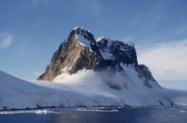 View across water towards snow covered mountain