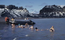 Tourists swimming in geothermally heated water which is considered an active volcano