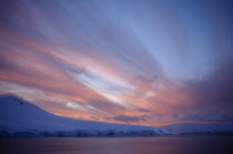 Orange sunset over glacial landscape.