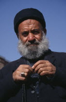 Portrait of an elderly man dressed in black with prayer beads