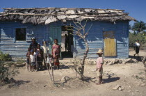 Extended family outside brightly painted home.