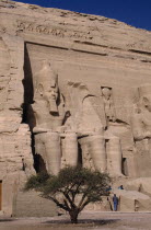 Sitting statues of Ramses the second at the temple carved in to a sandstone cliff