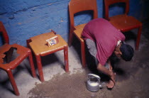 Boy sitting on a chair washing his feet Market