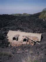 A house destroyed by lava flow .  2001-02 Eruption of Volcano