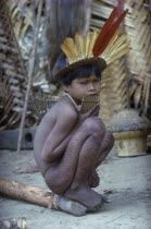 Young boy with  we  dark purple leaf dye and a crown of macaw and toucan feathers  plays the  carizu  panpipesTukano / Makuna    Indigenous Tribes  rio Piraparana North West Amazonia Amazon American...