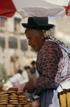 An elderly woman at a market stall.