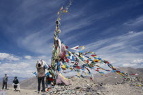 Tibetans adding katas  Buddhist ceremonial scarves  to the prayer flags at the top of Tscho La.