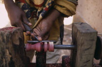 Close up of the hands of an Artisan carving a piece of rosewood