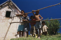 Near Ambositra. Rural family leaning on make shift wooden fence