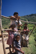 Near Ambositra. Rural family leaning on make shift wooden fence