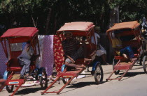 Men drivers sitting in the shade of their Rickshaws waiting for a fare