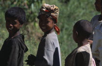 Portrait of a girl wearing a headscarf standing amongst two other children