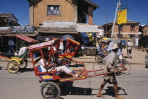 Rickshaws with passengers traveling along road