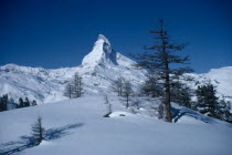 Looking across snow covered landscape towards peak of the Matterhorn.