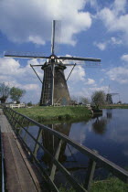 Windmill seen from across a narrow footbridge over water  Netherlands