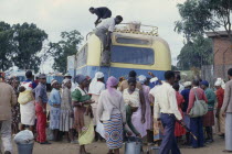 Crowds around unloading bus.