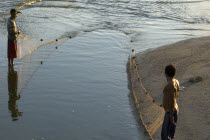 Fishermen at a small fresh water estuary fishing  Juan Griego Port.