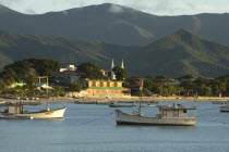 Sunset over Juan Griego Port  with boats in foreground and church in background.