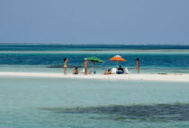 Tourists sunbathing on Rasqui cay  deck chairs and parasols.    umbrella