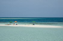 Tourists sunbathing on Rasqui cay  deck chairs and parasols.      umbrella