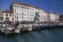 Gondolas moored against the Riva degli Schiavoni with the Londra Palace Hotel behind.