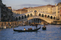 The Grand Canal and Rialto Bridge with gondola crossing in the foreground.