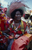 Three-quarter portrait of woman at a Ra Ra procession wearing wide brimmed straw hat