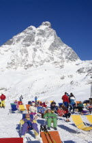 Group of skiers sunbathing at the foot of the Matterhorn.