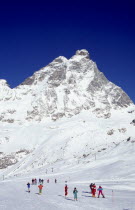 Skiers on slopes at the foot of the Matterhorn.