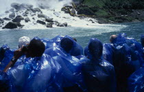 Maid of the Mists tourists in blue waterproofs looking toward American Falls