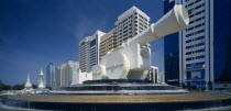 Al-Ittihad Square with huge sculpture of a cannon set on a circular tiered waterfall with modern high rise buildings behind. United Arab Emirates