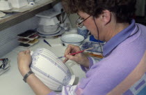 Female worker painting design onto delftware vase. Netherlands