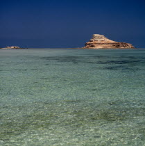 Nr Ruwais  Az Zabbut small rocky island surrounded by  clear turquoise sea with blue sky United Arab Emirates