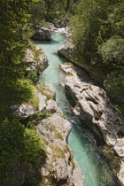 Viewed from Felika Korita Soce a narrow wooden suspension bridge  flowing through rocks shaped by the power of the water  Clear blue waternarrow gorgelimestone rocksclean waterimportant river