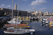 View across the harbour with moored boats towards Mosques  Minarets and an ancient fortress