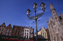 The Markt  Market Place .  Line of cafe awnings and red umbrellas of outside tables with street lamp in the foreground.