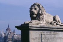 Stone statue of lion on Chain Bridge with Parliament building in distance behind.Eastern Europe  Eastern Europe