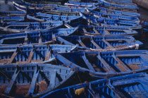 Blue and green fishing boats moored closely together.