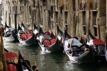 Gondoliers resting in their gondolas moored along the Rio San Moise canal