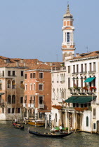 Gondolas with sightseeing tourists on the Grand Canal with the bell tower of the chursh of Santi Apostoli behind palazzos lining the canal