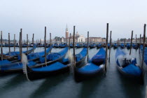 Gondolas moored at dusk in the Molo San Marco basin with Palladios church of San Giorgio Maggiore on the island of the same name in the distance