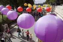 The Paris Plage urban beach. Colourful lanterns hanging above pedestrians strolling along the Voie Georges Pompidou a usually busy road closed to traffic opposite the Ile de la Cite Colorful