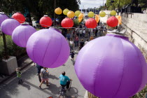 The Paris Plage urban beach. Colourful lanterns hanging above pedestrians strolling along the Voie Georges Pompidou a usually busy road closed to traffic opposite the Ile de la Cite Colorful